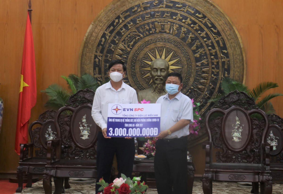  Ông Nguyễn Văn Út, Chủ tịch UBND tỉnh Long An (phải) tiếp nhận nguồn kinh phí 3 tỷ hỗ trợ công tác phòng chống dịch do đại diện Cty Điện lực Long An thay mặt EVNSPC trao.