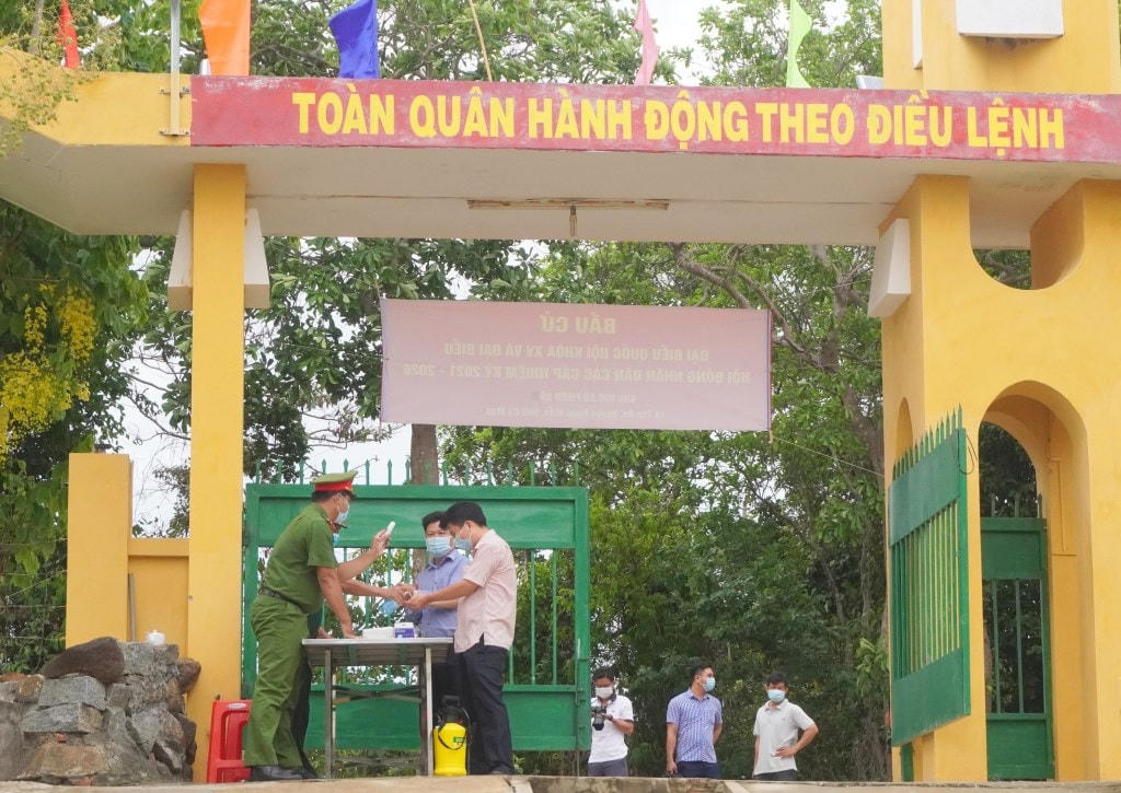 Cử tri được kiểm tra thân nhiệt, sát khuẩn và thực hiện khai báo y tế trước khi vào khu vực bầu cử. Ảnh: dangcongsan.vn.  