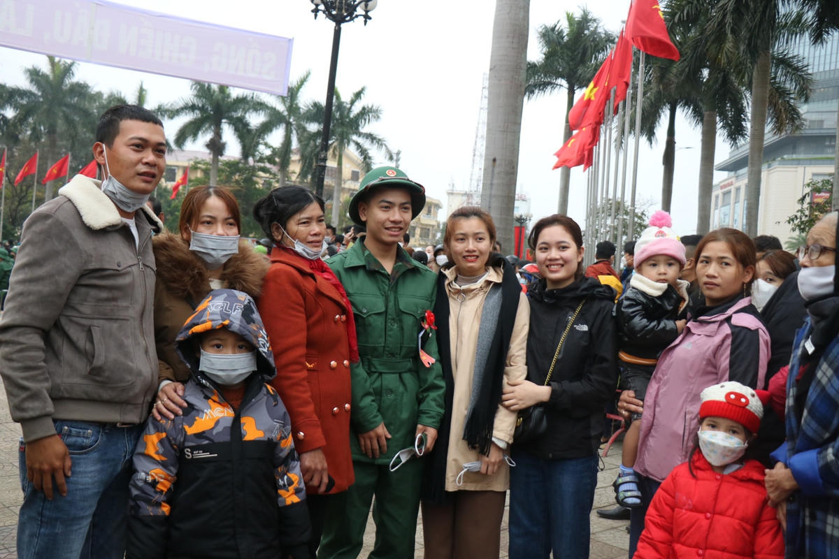 Người thân, bạn bè chụp ảnh kỷ niệm trước giờ nam thanh niên lên đường nhập ngũ. Ảnh: Nguyễn Quốc.