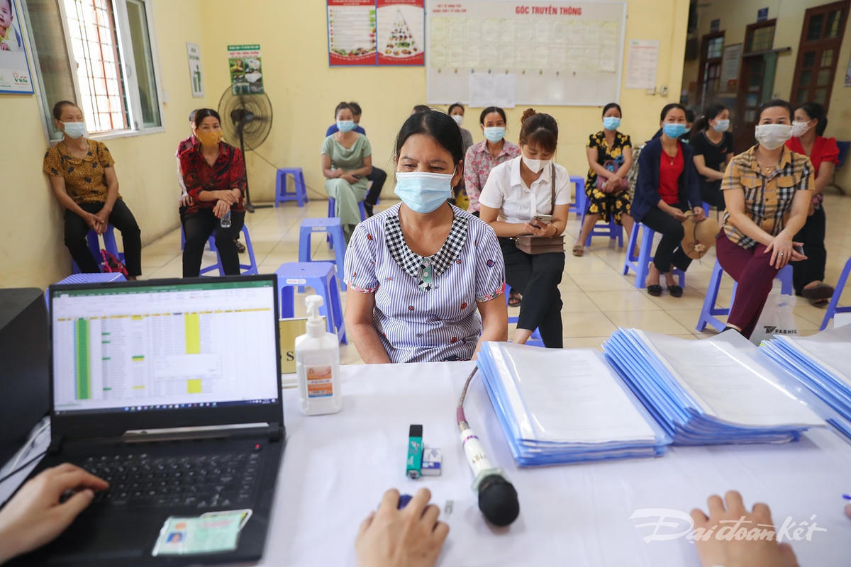 Những người dân đến tham gia thử nghiệm lâm sàng vaccine Nanocovax ngồi giữ đúng khoảng cách, đeo khẩu trang, thực hiện từng bước theo hướng dẫn. Ảnh: Quang Vinh. 