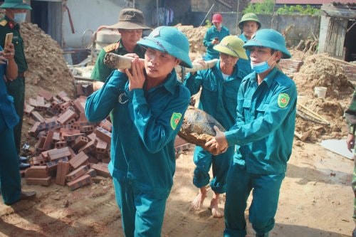 Lực lượng dân quân tự vệ di dời bom ra khỏi khu vực nhà dân.