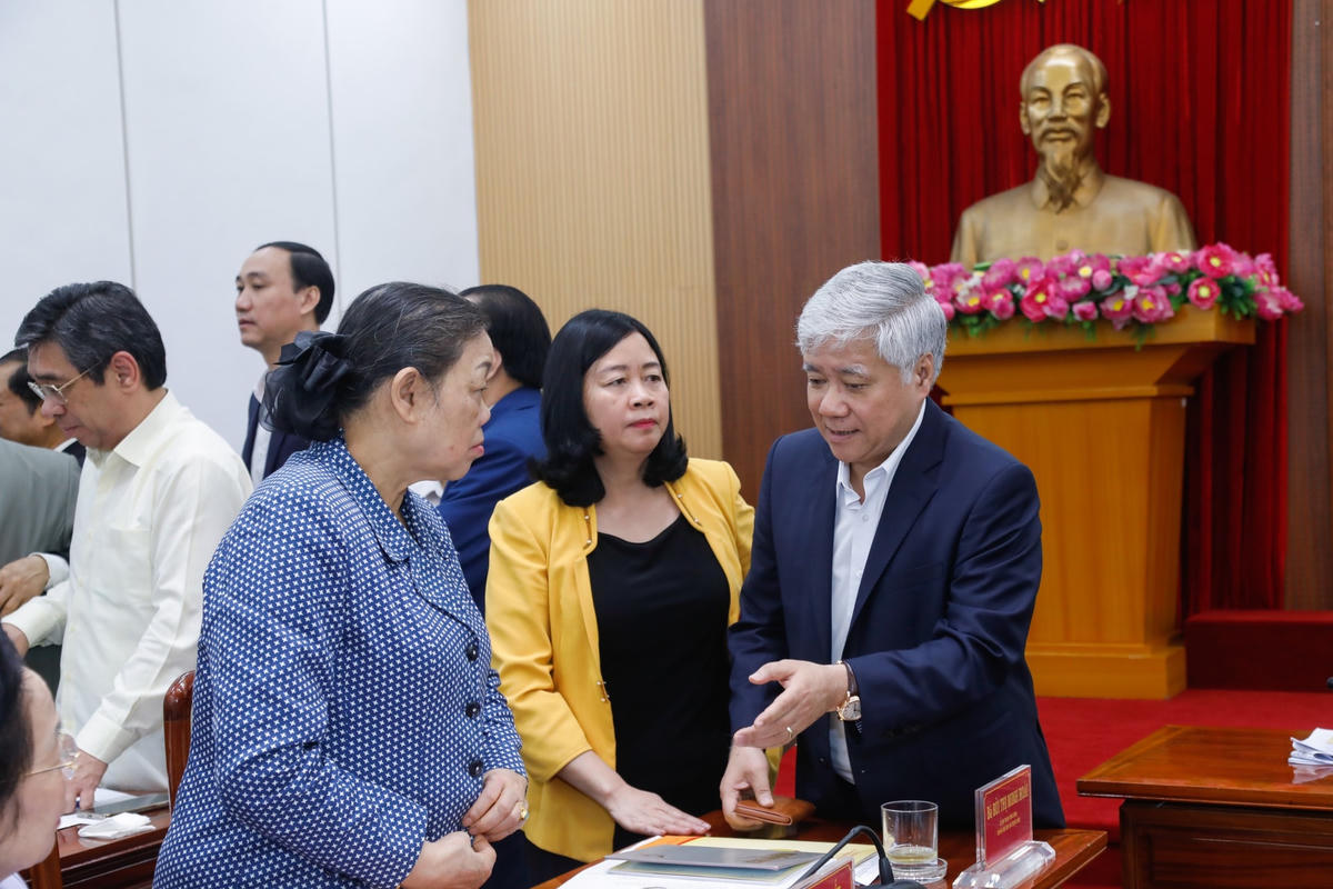 Chủ tịch Đỗ Văn Chiến trao đổi với các đại biểu dự Hội nghị.