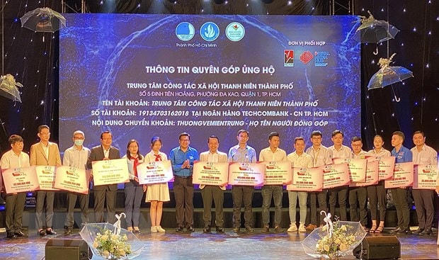 Đại diện các tổ chức, doanh nghiệp, đơn vị trao bảng tượng trưng số tiền ủng hộ miền Trung cho Ban tổ chức. (Ảnh: Hồng Giang/TTXVN).