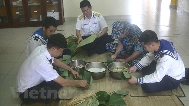 Các chiến sỹ nhà giàn gói bánh chưng. (Ảnh: Quang Vinh/Vietnam+).