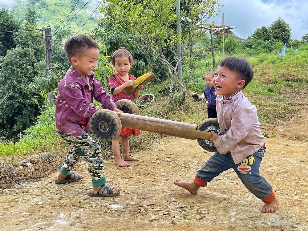 Các em nhỏ ở xã Sin Suối Hồ, huyện Phong Thổ, tỉnh Lai Châu háo hức khi được các anh lớn trong nhà chế cho chiếc 'ôtô 3 bánh. Ảnh: Mai Mai/Vietnam+.  