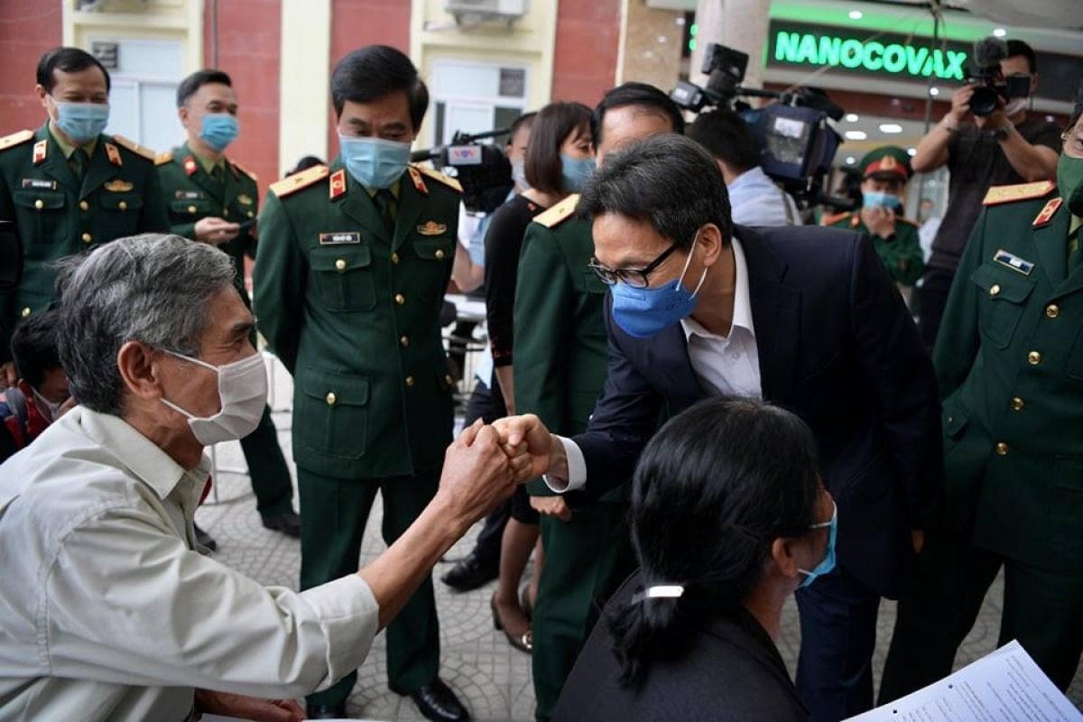 Phó Thủ tướng Vũ Đức Đam động viên tình nguyện viên thử vaccine Covid-19. Ảnh: TTXVN.