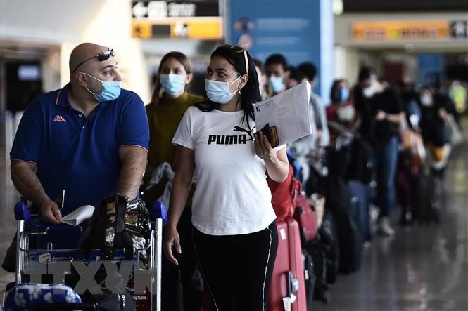 Hành khách đeo khẩu trang phòng lây nhiễm Covid-19 tại sân bay Fiumicino ở Rome, Italy. (Ảnh: AFP/TTXVN).