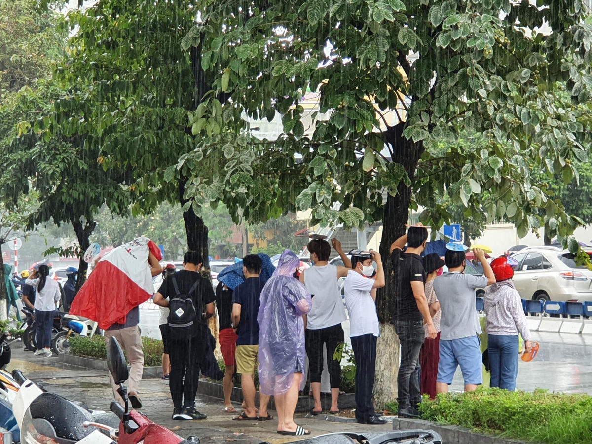 Mưa như trút nước, mỗi lúc một to hơn, nhiều phụ huynh tập trung lại dưới các tán cây tránh mưa.