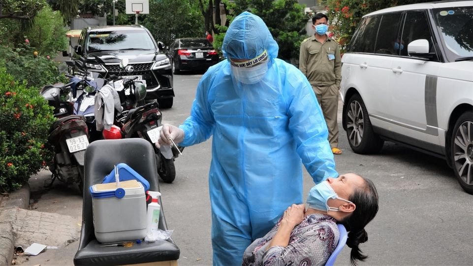 Lấy mẫu xét nghiệm người dân sống xung quanh nơi cư trú của ca nhiễm Covid-19. Ảnh: HCDC.
