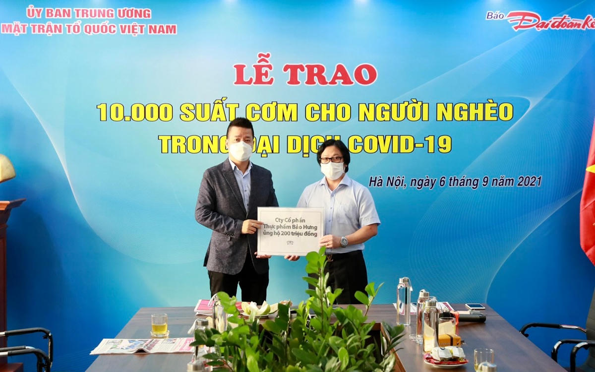 Quyền Tổng Biên tập Lê Anh Đạt nhận ủng hộ 200 triệu đồng hỗ trợ chương trình từ ông Nguyễn Đại Huệ - đại diện Công ty Cổ phần Quốc tế Bảo Hưng. Ảnh: Quang Vinh.