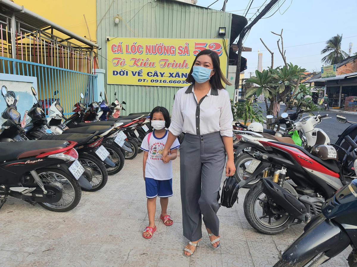 Phụ huynh đưa trẻ 5 tuổi lớp lá đến trường sau thời gian gần 10 tháng gián đoạn vì dịch Covid-19.