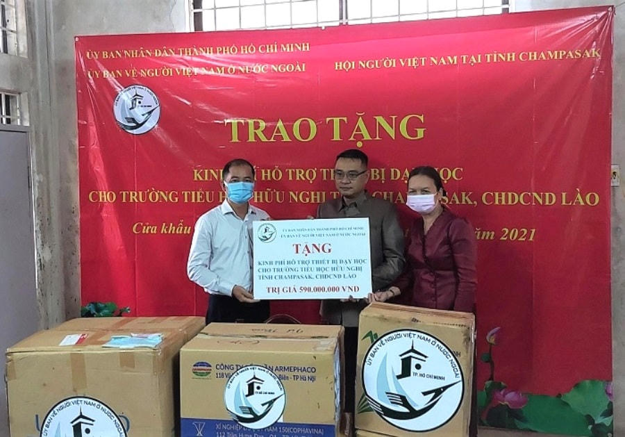 Ông Trần Đức Hiển (bên trái), Phó Chủ nhiệm Ủy ban về người Việt Nam ở nước ngoài TP HCM trao tặng kinh phí cho Trường Tiểu học Hữu nghị tỉnh Champasak.