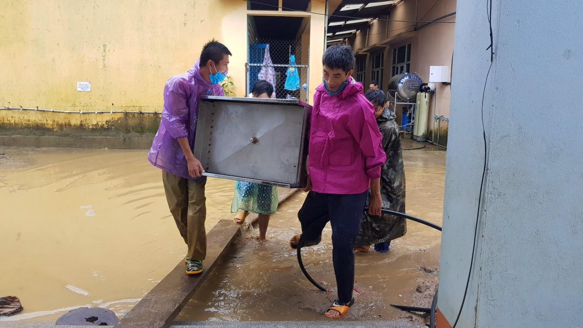 Các thầy cô đang chuyển đồ đạt vào phòng học.