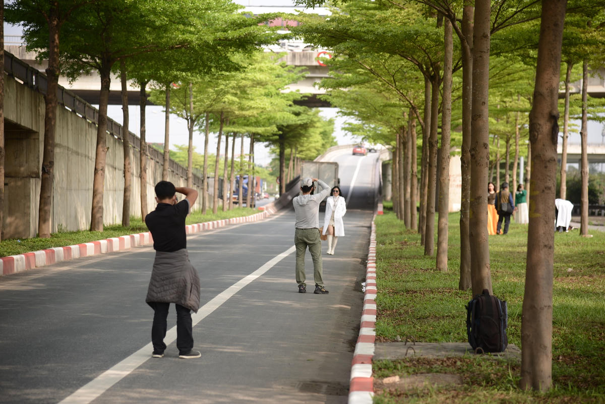 Những lúc có xe, người dân vội chạy lên vỉa hè để tránh xe. Tuy nhiên, khi xe đi qua, người dân lại tràn xuống đường tiếp tục chụp ảnh..