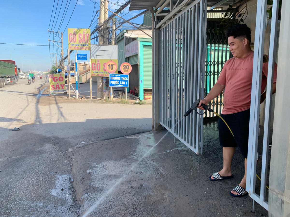 Tưới nước thường xuyên là cách để người dân làm giảm lượng bụi bám vào nhà mình.