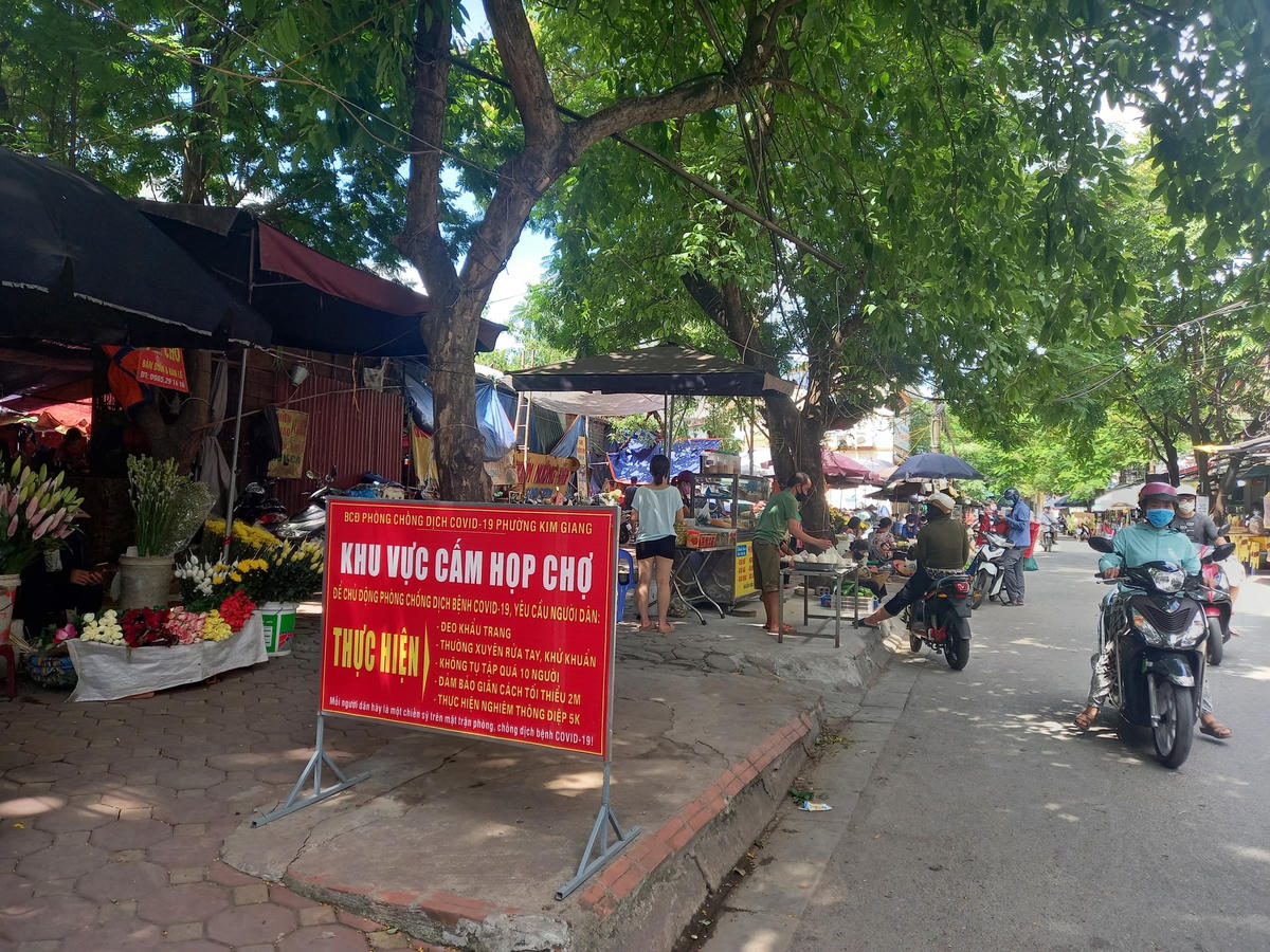 Tại khu vực chợ tạm ngõ 64 Kim Giang, địa phận giáp ranh giữa 2 phường Kim Giang (quận Thanh Xuân) và phường Đại Kim (quận Hoàng Mai) người dân vẫn vô tư họp chợ cạnh biển cấm.