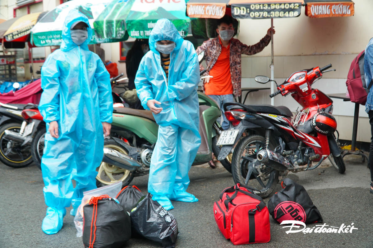 Người dân được trang bị đồ bảo hộ trước khi vào ga lên tàu.