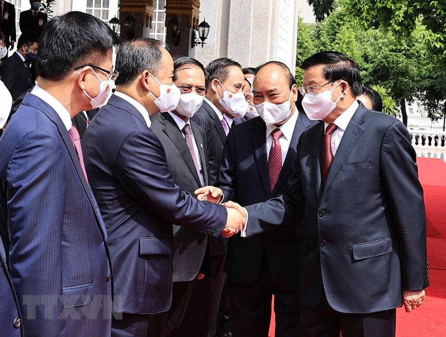 Chủ tịch nước Cộng hòa Xã hội chủ nghĩa Việt Nam Nguyễn Xuân Phúc và Tổng Bí thư, Chủ tịch nước Lào Thongloun Sisoulith với các thành viên đoàn đại biểu cấp cao 2 nước tại lễ đón. (Ảnh: Thống Nhất/TTXVN).