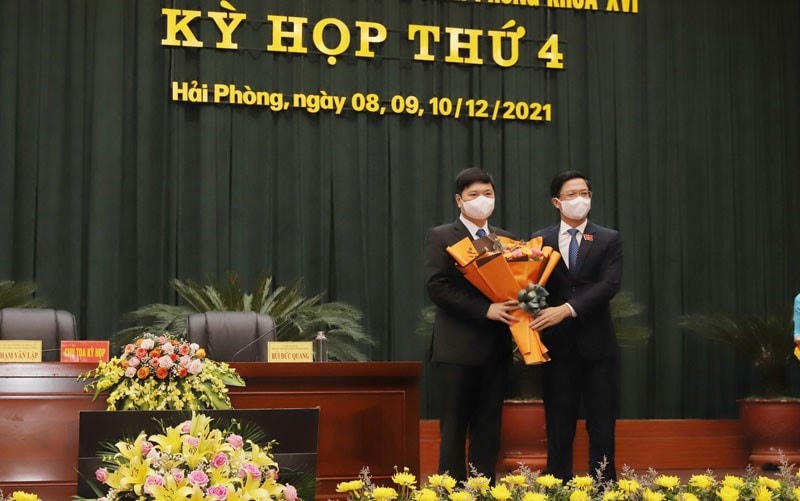 Ông Hoàng Minh Cường (đứng bên trái) nhận hoa chúc mừng từ Chủ tịch HĐND TP Hải Phòng Hoàng Văn Lập.