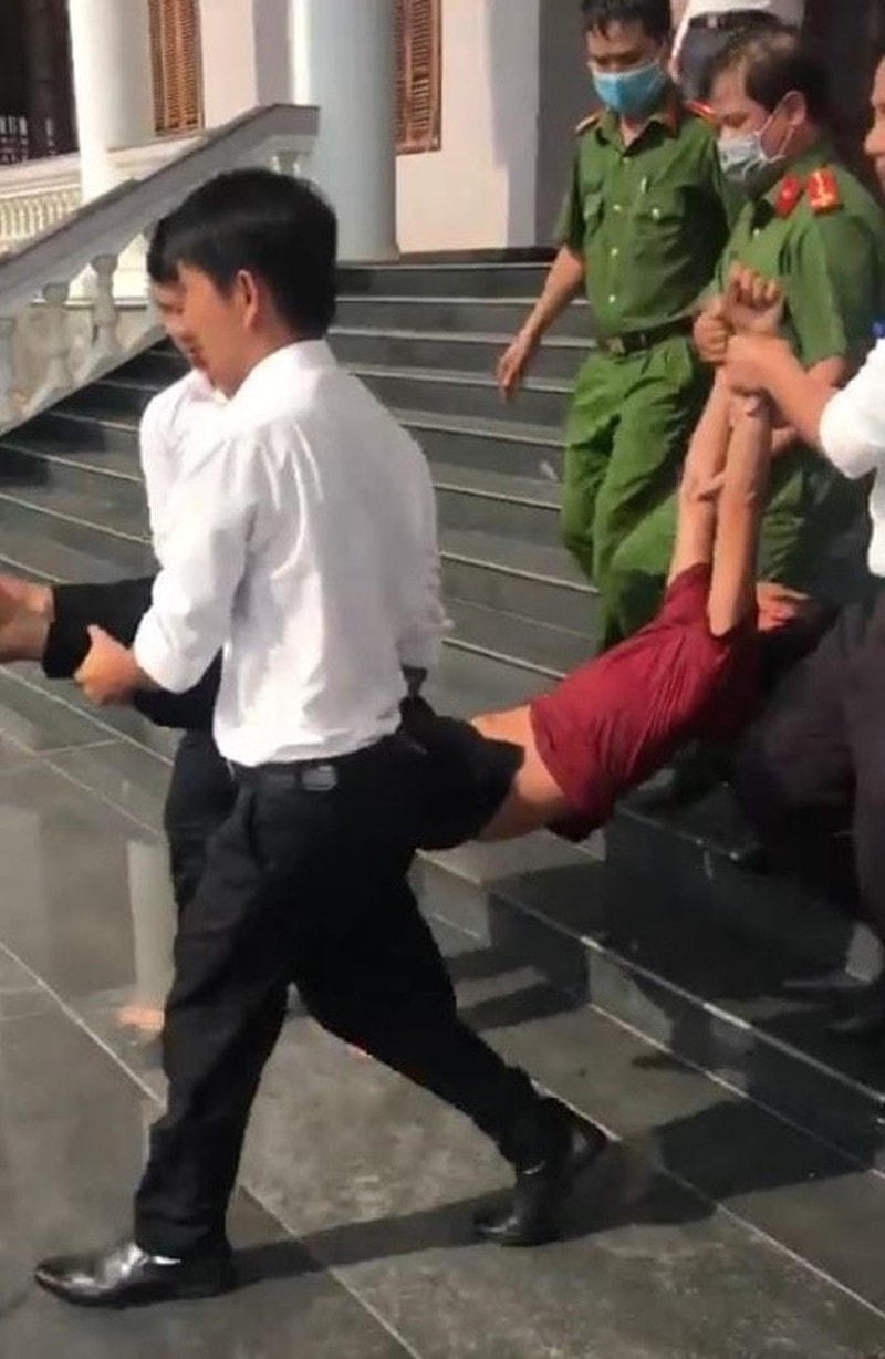 Công an và cán bộ TAND Bình Phước đưa Hào ra xe cấp cứu. Ảnh: Lê Ánh.
