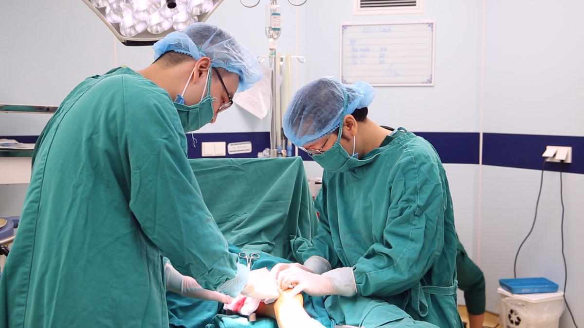 Các bác sĩ thực hiện ghép da tự thân cho trẻ.
