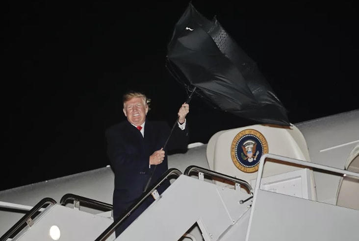 Chiếc ô của Tổng thống Mỹ Donald Trump bị bật ngược bởi một cơn gió khi ông bước ra khỏi chiếc Không lực Một, năm 2018.