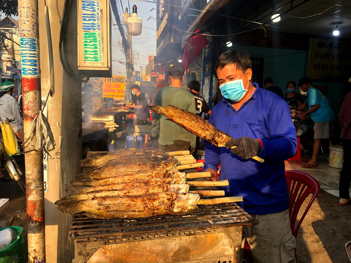 Nhiều người dân xếp hàng dài mua cá lóc nướng. Cá nướng chín ngay tại tiệm có cá rau sống, nước chấm và bún được bán với giá từ 170 tới 200 ngàn đồng/con. Người dân thường mua cá theo cặp (2 con) để cúng ngày này. Mỗi con cá thường mất 1 giờ đồng hồ nướng trên than mới chín.