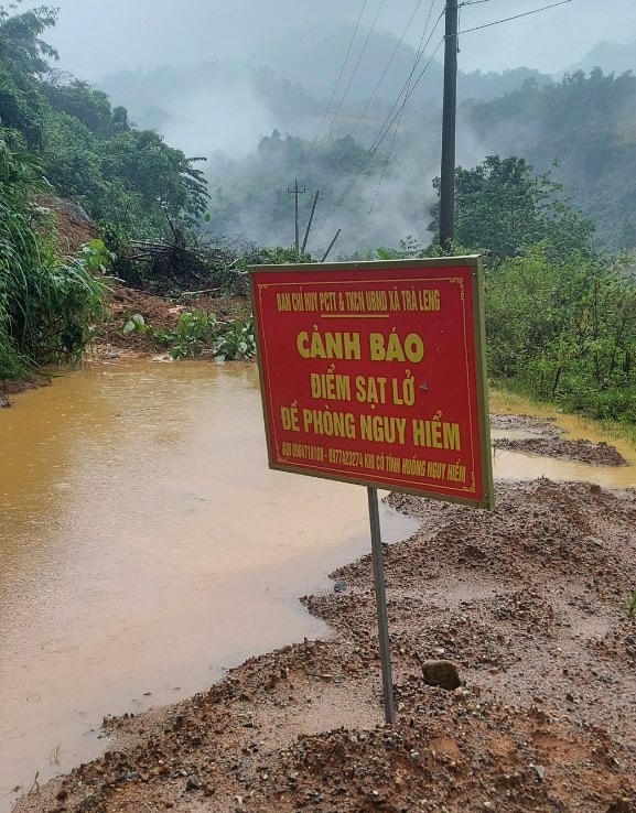 Lực lượng chức năng cắm biển cảnh báo đoạn đường sạt lở.