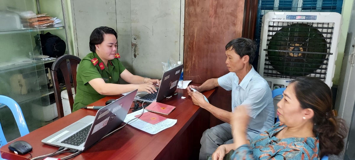 Gần 12 giờ trưa, đại úy Phạm Thị Mai Liên vẫn vui vẻ nhập dữ liệu cho người dân. Ảnh: Trung Lĩnh