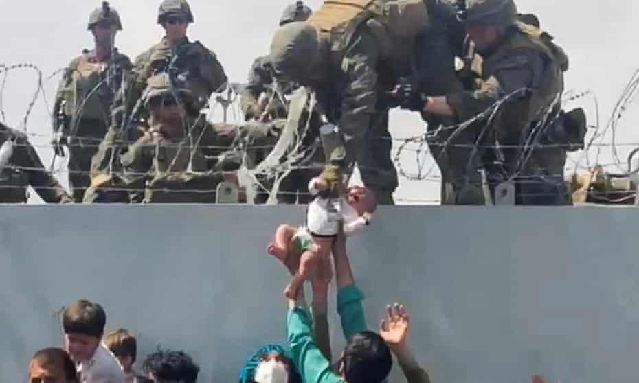 Em bé được giao cho lực lượng quân đội Mỹ tại sân bay Kabul trong cuộc sơ tán vào tháng 8/2021. Ảnh The Guardian.  