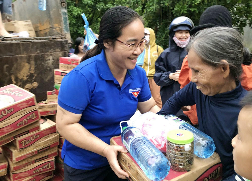 Chị Nga trao quà cho người dân vùng lũ.  