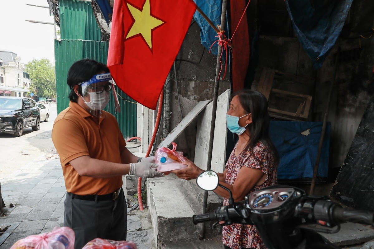 Quyền Tổng Biên tập Báo Đại Đoàn Kết Lê Anh Đạt trao suất ăn cho người nghèo.