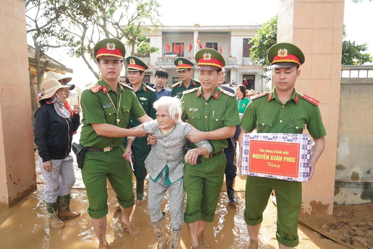 Người dân được chiến sĩ cứu hộ đưa ra khỏi vùng ngập lụt. Ảnh: Quang Hiếu.
