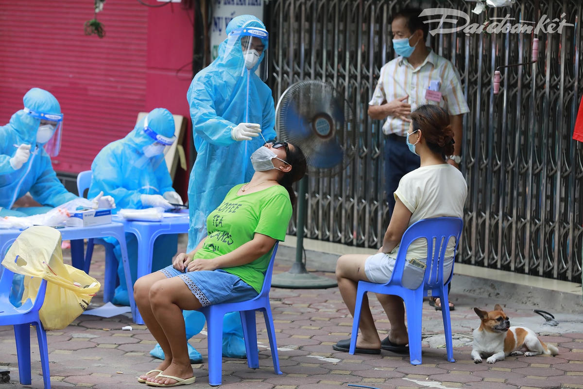 Khu vực lấy mẫu được sắp xếp ngay tại các khu dân cư, tránh để người dân phải di chuyển xa. Từng người dân xếp hàng, thực hiện nghiêm túc các quy định về phòng, chống dịch Covid-19 như đeo khẩu trang, giữ khoảng cách. Ảnh: Quang Vinh. 