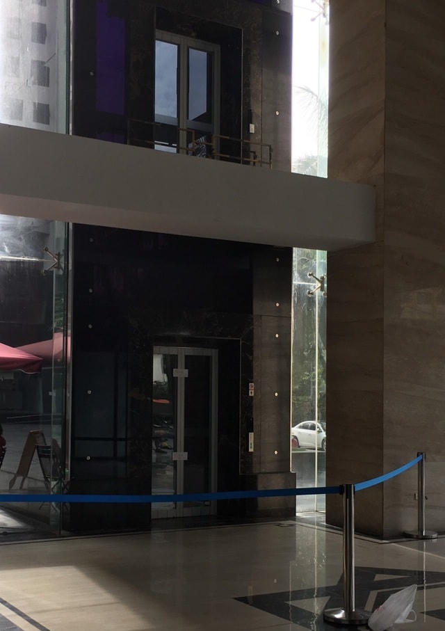 Hiện cửa thang đã được đặt barie ngăn không cho ai sử dụng. Dưới tầng 1 nơi người đàn ông ngã xuống cũng đã được căng dây chắn lại. Ảnh: Dân Trí.