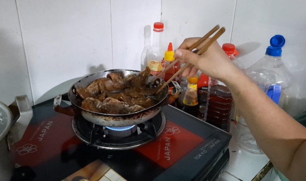 Chị Vân chiên lại cá mang từ công ty về.