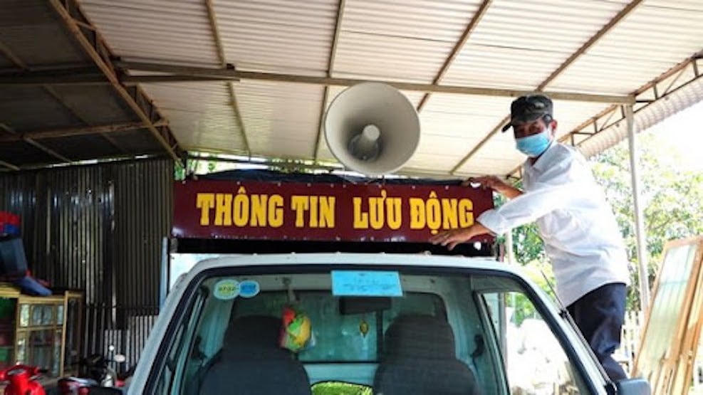 Ông Nguyễn Hữu Đức, Trưởng ban Công tác Mặt trận ấp Thọ An bên chiếc xe được ông trưng dụng tham gia phòng, chống dịch.