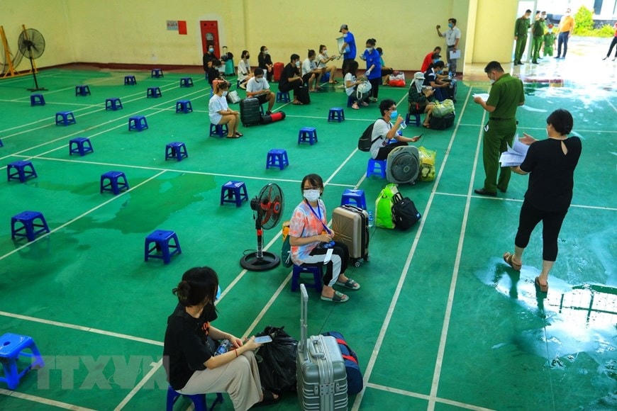 Ủy ban Nhân dân quận Thanh Xuân đón người từ ký túc xá Trường Đại học FPT về Nhà văn hóa quận Thanh Xuân sau khi hoàn thành cách ly 21 ngày theo quy định. (Ảnh: Tuấn Anh/TTXVN)