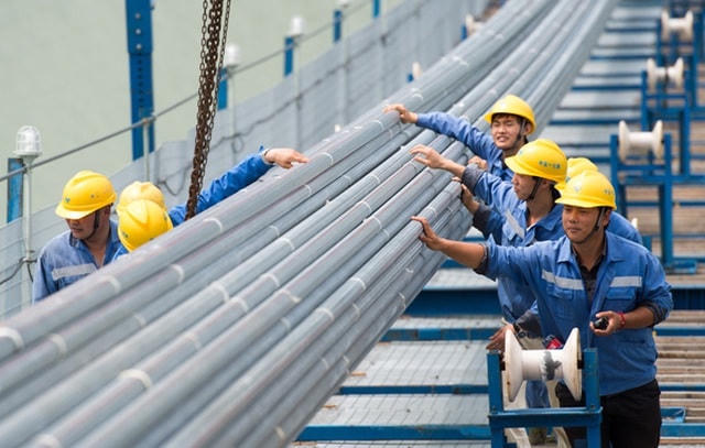 Các nhân viên kỹ thuật của Công ty Xây dựng Giao thông Trung Quốc (CCCC) kiểm tra các tuyến cáp. (Ảnh: Xinhua).