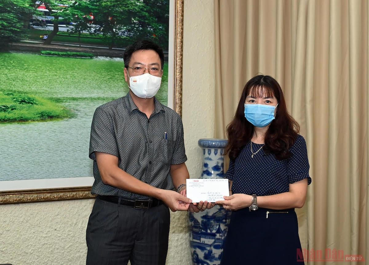 Ông Phan Huy Thắng, Trưởng Ban thư ký Biên tập Báo Nhân Dân trao quà hỗ trợ của các cựu sinh viên khoa Báo chí cho đại diện nhà trường.  