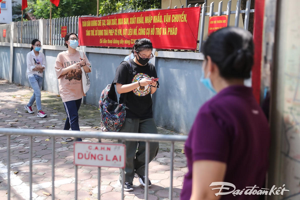 Một người mẹ đang đứng chờ con, chị tỏ ra khá sốt ruột khi vẫn chưa thấy con ra khỏi điểm thi dù khá nhiều bạn thí sinh đã ra đến đây. Ảnh: Quang Vinh. 