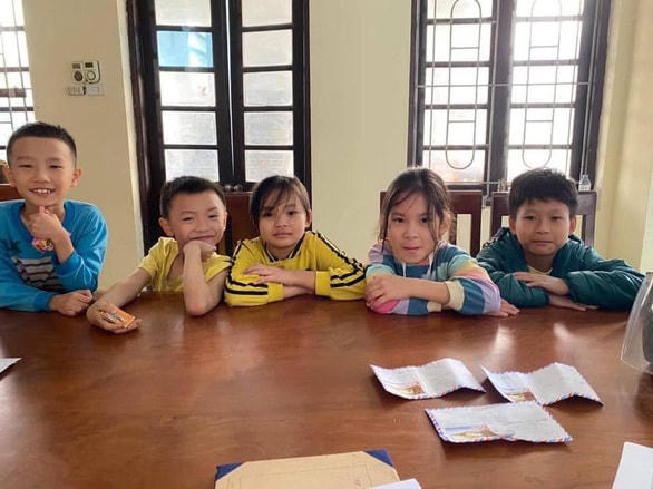 5 em học sinh Trường tiểu học thị trấn Phùng và 3 chiếc phong bì nhặt được đưa cho Đội Cảnh sát giao thông, trật tự nhờ tìm người đánh rơi - Ảnh: Công an cung cấp