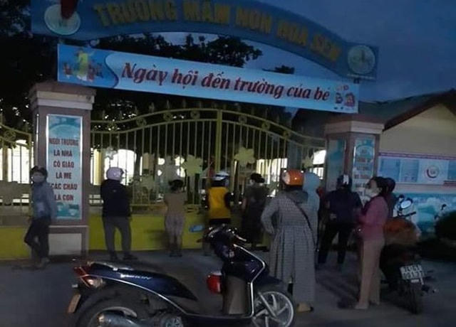 Tối 27/9, trong khi học sinh ở lại trường để đợi kết quả xét nghiệm Covid-19, nhiều phụ huynh đứng bên ngoài cổng trường để theo dõi tin tức của con em mình. Ảnh: Người Cam Lộ.