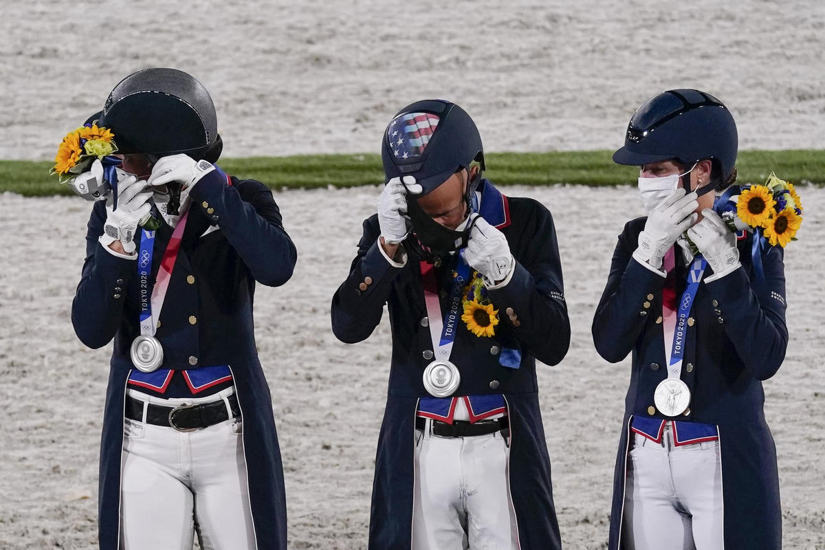 Adrienne Lyle, Steffen Peters và Sabine Schut-Kery tháo khẩu trang sau những bức ảnh ăn mừng huy chương bạc môn Cưỡi ngựa. (Ảnh: AP / Carolyn Kaster).