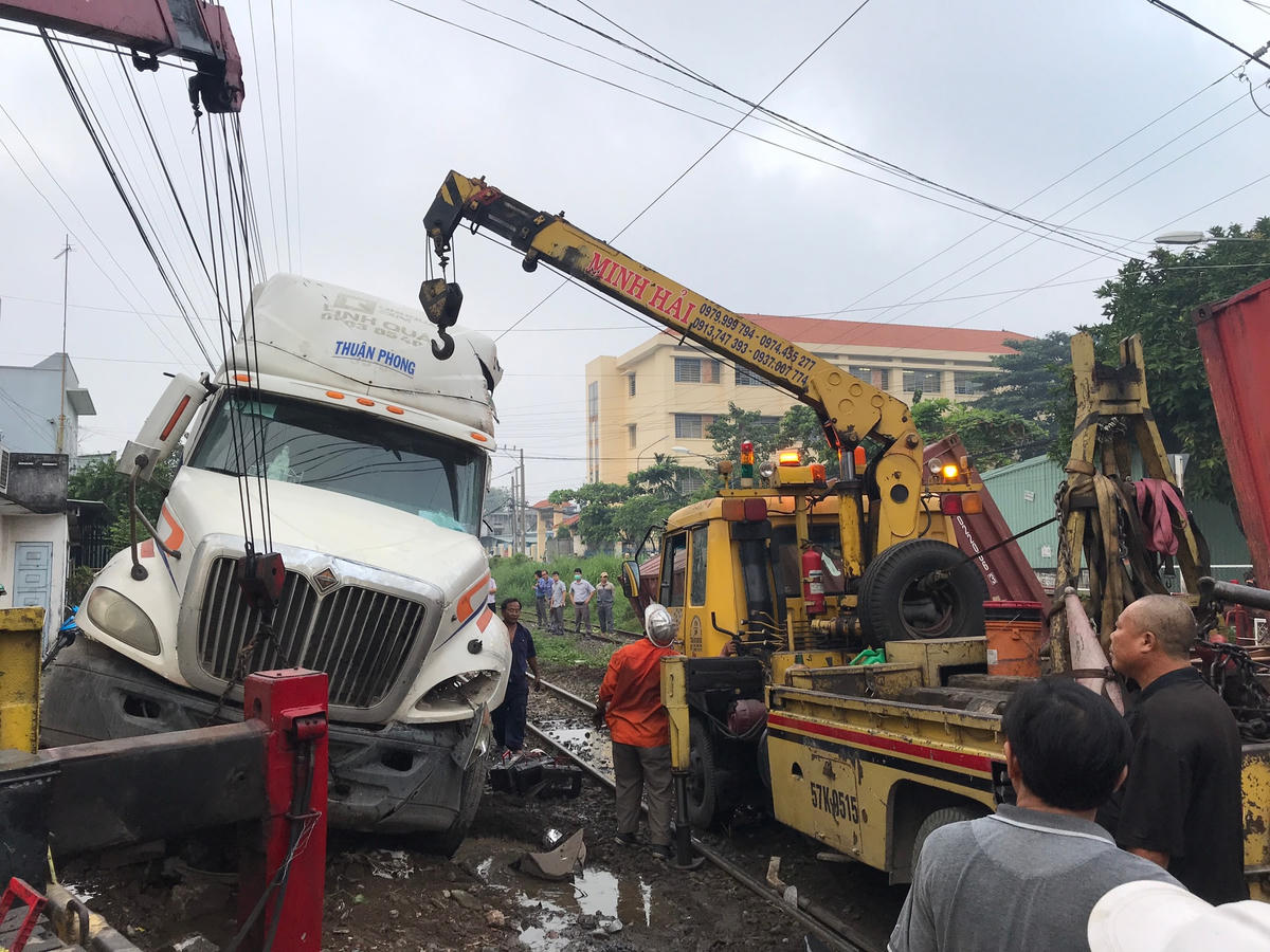 Lực lương cứu hộ cẩu xe container ra khỏi đường rày tàu hỏa.