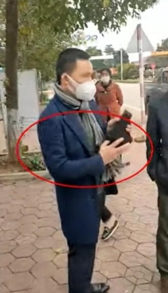 Người đàn ông rút súng từ một vỏ bao màu đen.