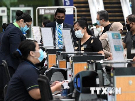 Hành khách làm thủ tục tại sân bay quốc tế Changi ở Singapore ngày 8/6/2020. (Ảnh: AFP/TTXVN).