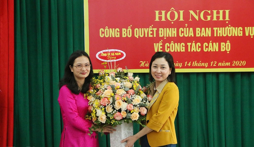 Phó Bí thư Thường trực Tỉnh ủy Hà Nam Đinh Thị Lụa (bên phải) trao quyết định điều động công tác cho bà Trần Thị Ngân.