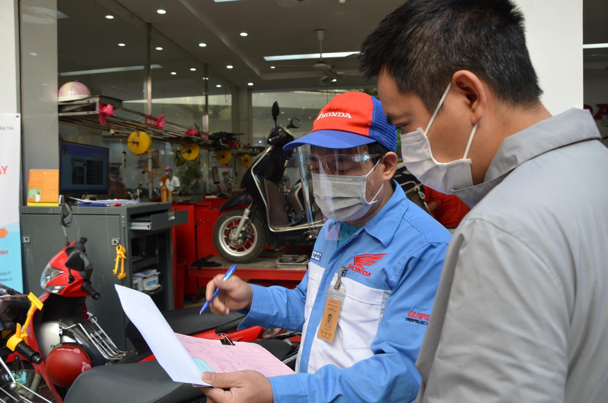 Nhân viên cửa hàng tư vấn về phương thức và chi phí sửa chữa phương tiện. 