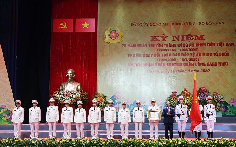 Thủ tướng Chính phủ Nguyễn Xuân Phúc gắn Huân chương lên lá Cờ truyền thống và trao Bằng Huân chương Quân công hạng Nhất tặng lực lượng CAND.